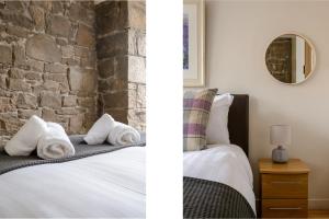 a bedroom with a brick wall and a bed with towels at The Lady Stair's Apartment - Royal Mile in Edinburgh
