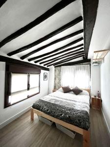 a bedroom with a bed and a large window at La casita del rio in Soto en Cameros