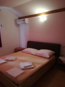 a bedroom with a bed with two towels on it at Apartments Donadic I, Caska in Novalja