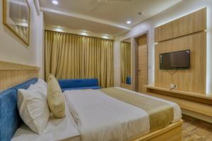 a bedroom with a large bed and a television at Hotel Centre Park Bhopal in Bhopal