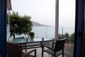 a table and chairs on a balcony with a view of the water at Villa Niki in Plataria