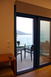 a sliding glass door with a view of the ocean at Villa Niki in Plataria