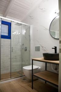 uma casa de banho com uma cabina de duche em vidro e um lavatório. em Villa Niki em Plataria