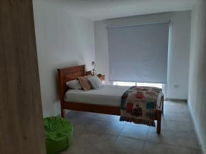 1 dormitorio con cama y ventana con sombra en Poas II en Santa Rosa