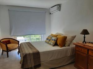 1 dormitorio con 1 cama, 1 silla y 1 ventana en Poas II en Santa Rosa