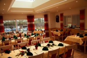 ein Restaurant mit Tischen und Stühlen in einem Zimmer in der Unterkunft Hotel Restaurant zur Windmühle in Ansbach