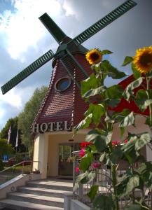 un moulin à vent devant un bâtiment doté d'une usine dans l'établissement Hotel Restaurant zur Windmühle, à Ansbach