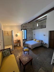 a bedroom with a bed and a couch in a room at Oustaou de Betty et Bob in Le Cailar