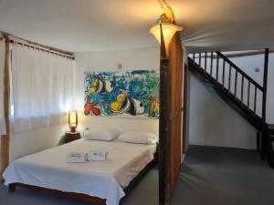 a bedroom with a bed with a painting on the wall at Hotel Playa Mandala in Palomino +32 photos