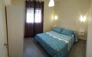 Un dormitorio con una cama con edredón azul y una ventana. en Casa Los Naranjos 3, en Cádiz 12 fotos más