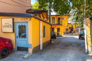 żółty budynek z niebieskimi drzwiami na ulicy w obiekcie Hotel Vamos Sarajevo, b&b w Sarajewie