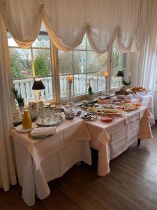 uma mesa com comida numa sala com janelas em Waldhotel "Peter aufm Berge" em Bielefeld