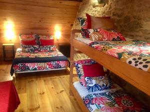 a room with three bunk beds with colorful pillows at Les Maitres Sonneurs in Huriel +85 photos