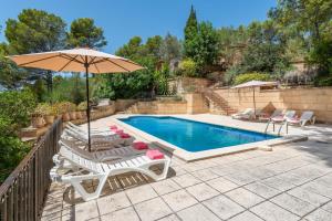 una piscina con tumbonas y sombrilla en NEW! Villa CAN PERE for 10 people with pool and panoramic views, en Es Capdellà