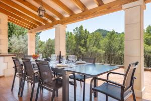 un patio con mesa de comedor y sillas en NEW! Villa CAN PERE for 10 people with pool and panoramic views, en Es Capdellà