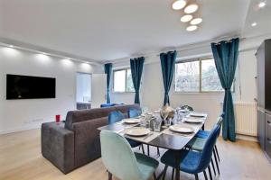 ein Wohnzimmer mit einem Tisch und einem Sofa in der Unterkunft TROCADERO/ EIFFEL TOWER - 3 Bedrooms- All New! in Paris