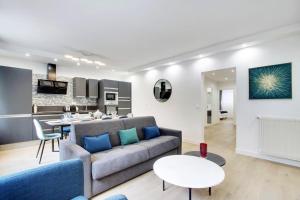 a living room with a couch and a table at TROCADERO/ EIFFEL TOWER - 3 Bedrooms- All New! in Paris