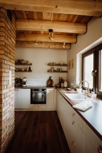 a kitchen with a sink and a brick wall at Chata Sękata in Baligród