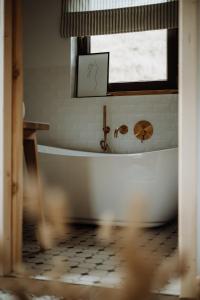 a white bath tub in a bathroom with a window at Chata Sękata in Baligród