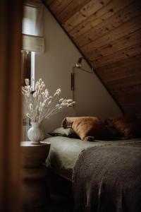 a bedroom with a bed and a vase with flowers at Chata Sękata in Baligród