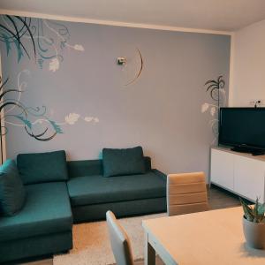 - un salon avec un canapé vert et une télévision dans l'établissement CASA VACANZE DA MARTI, à Tirano