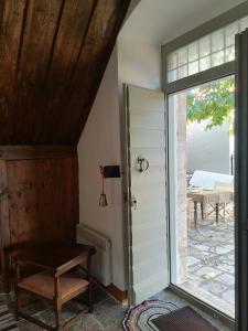 a room with a door and a chair and a table at The Doctor’s Mansion - Arkadia in Lagkadia