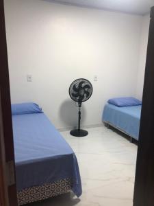 um quarto com duas camas e uma ventoinha em Apartamento bem localizado na Av.Principal em Manaus
