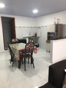 a dining room with a table and chairs and a kitchen at Apartamento bem localizado na Av.Principal in Manaus