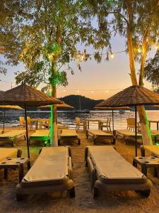 a group of tables and umbrellas on a beach at Marimare Beach & Bungalow in Marmaris