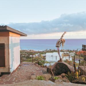 une personne debout sur un rocher en face de l'océan dans l'établissement Native Residence, à Rosarito