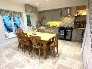 a kitchen with a wooden table and chairs at Superb House in Looe, Near Beach and Bars with Great Views and free access to a nearby Indoor Swimming Pool in Looe