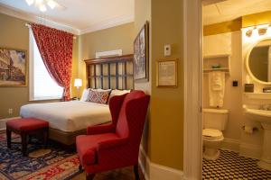 a bedroom with a bed and a chair and a toilet at The Marshall House, Historic Inns of Savannah Collection in Savannah