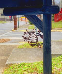 a blue sign with a painting on the side of a street at Vine City Bee Hive in Atlanta