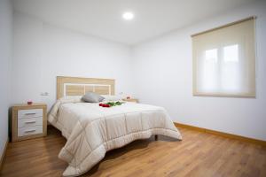biała sypialnia z łóżkiem i oknem w obiekcie Casa Peña Dura w mieście Lalín