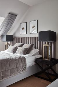 1 dormitorio con 1 cama con 2 lámparas en una mesa lateral en Farma Bii, en Brzeziny