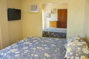 Habitación de hotel con 2 camas y TV en Maravilhoso apartamento de 2 quartos com vista mar, en Cabo Frío