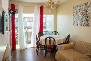 a living room with a table and chairs and a couch at Maravilhoso apartamento de 2 quartos com vista mar in Cabo Frio
