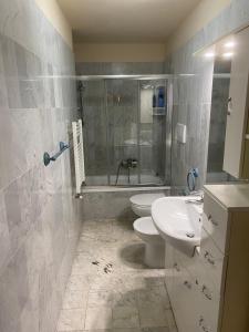 a bathroom with a toilet and a sink and a shower at Renovated apartment with 3 bedrooms in an historic palazzo between port and old town in Livorno +30 photos