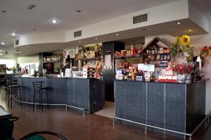 a bar in a restaurant with a woman standing at the counter at Hotel Ria de Vigo "Tierra de Campos" in Becilla de Valderaduey