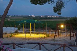 un parque infantil con una sombrilla verde y un columpio en Residence Casale Verderame, en Trapani