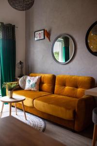 żółtą kanapę w salonie z lustrem w obiekcie Apartament Panorama De Lux Family w Koszalinie