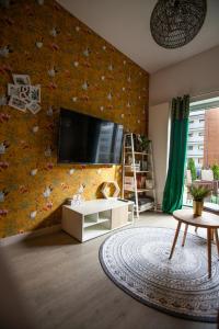 a living room with a flat screen tv on a wall at Apartament Panorama De Lux Family in Koszalin