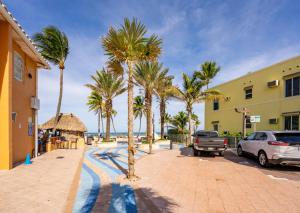 una calle con palmeras y un coche estacionado al lado de un edificio en The Surf Hollywood Beach, en Hollywood