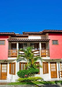 a building with a palm tree in front of it at Residencial Mont Sinai Tonziro -Taperapuan in Porto Seguro