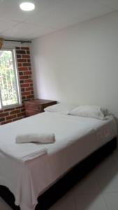 a bedroom with a white bed with two towels on it at Apartamento Amoblado en Ibagué in Ibagué