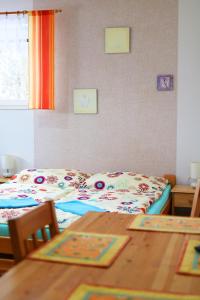 a bedroom with two beds and a wooden table at Apartmany Jana in Janske Lazne