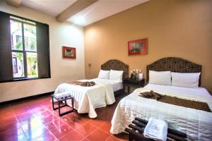 um quarto de hotel com duas camas com lençóis brancos em Hotel Merida em Mérida