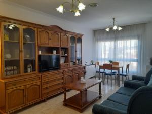 a living room with a large wooden entertainment center at Martínez Rooms Pilgrims in Caldas de Reis