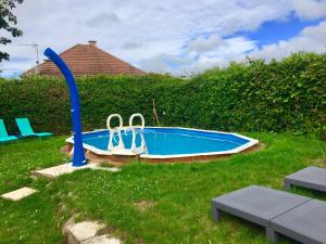 a small swimming pool in the grass next to a hedge at Yourte mongole in Huriel