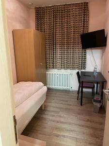 a room with a couch and a table and a desk at Relax Hotel-Ludwigshafen in Ludwigshafen am Rhein